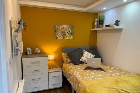A bright and inviting double bedroom with styli...