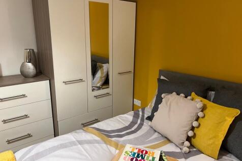 A bright and inviting double bedroom with styli...