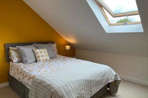 A bright and inviting double bedroom with a coz...