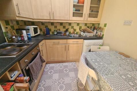 A cozy kitchen area featuring wooden cabinets a...