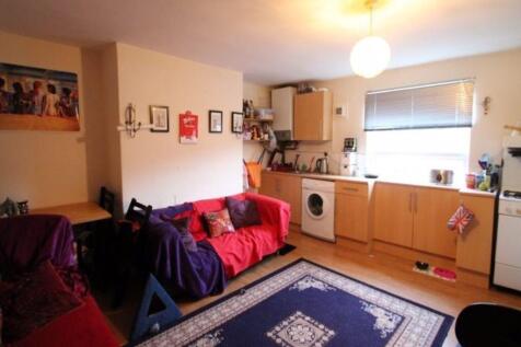 A spacious and well-lit living room featuring c...