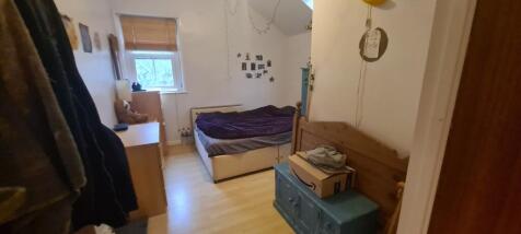 A cozy bedroom with a single bed, a small windo...