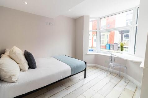 Bright and airy bedroom with large windows fill...