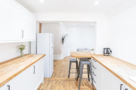 Bright and modern kitchen with white cabinetry ...