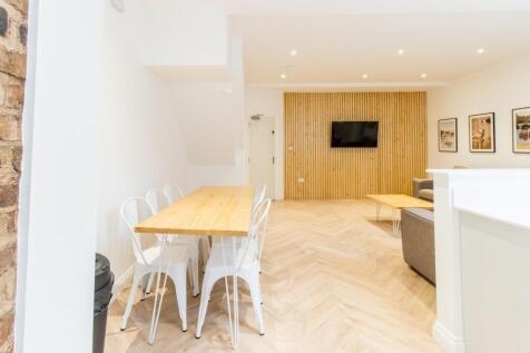 Bright, modern communal living area with a long...