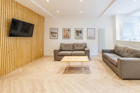 Bright, contemporary living room with two comfo...