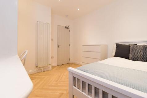 Bright, modern double bedroom with light wood f...