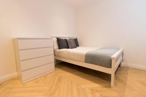 Bright, modern double bedroom with a white wood...