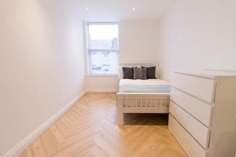 Bright, simply furnished bedroom with a neatly ...