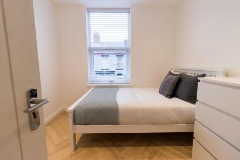 Bright, neatly presented bedroom with a white f...
