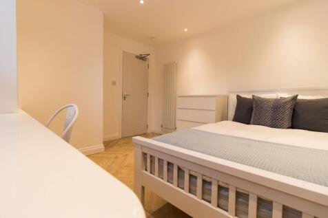 Bright, modern double bedroom with a white fram...