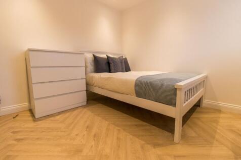 Bright, simply styled bedroom with a white wood...