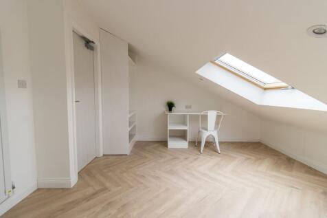 Bright loft bedroom with a skylight, pale herri...