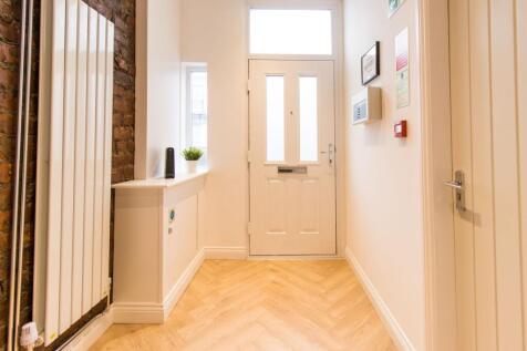 Bright, modern entrance hallway with chevron wo...