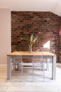 Stylish dining area with a solid wood table, cl...