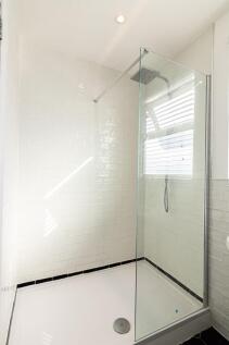 Bright, modern shower with white subway tiles, ...