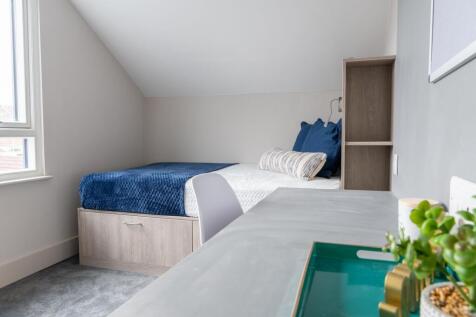 A bright and modern bedroom featuring a comfort...