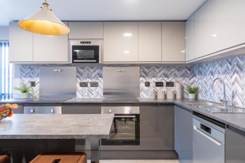 This modern kitchen features sleek cabinetry, s...
