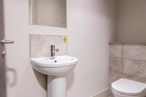 A clean, modern bathroom featuring a white sink...