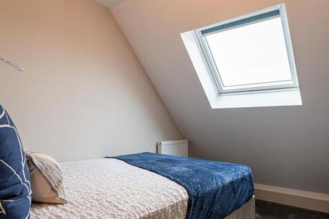 A cosy single bedroom featuring a comfortable b...