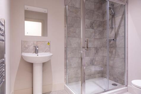 Modern bathroom featuring neutral-toned tiles, ...