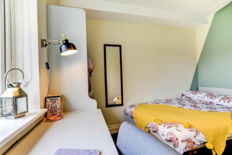 Bright and cozy master bedroom featuring a comf...