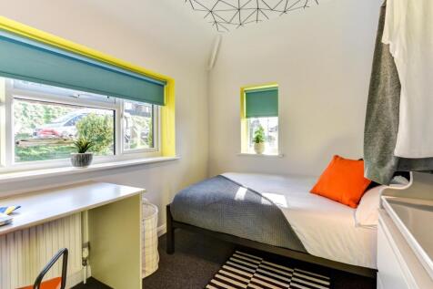 This cozy double bedroom features large windows...