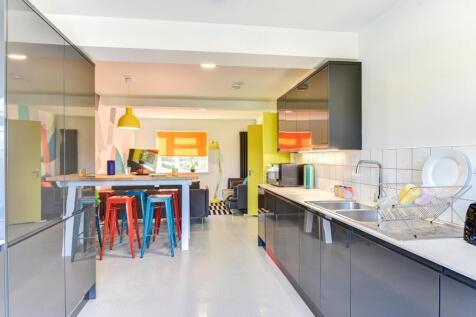 Modern kitchen featuring sleek black cabinetry,...