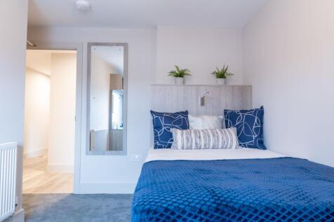 A bright, modern bedroom featuring a cozy bed w...