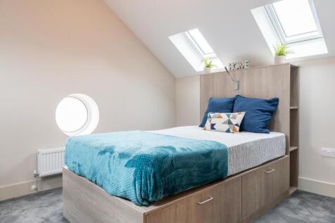 A stylish double bedroom featuring bright skyli...