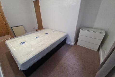 A well-maintained double bedroom with a comfort...