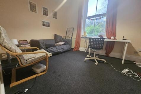 A comfortable living room featuring a sofa, an ...