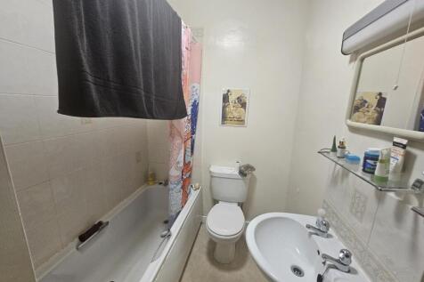 A well-maintained bathroom featuring a bathtub,...