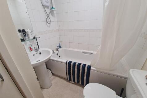 A well-maintained bathroom featuring a bathtub ...