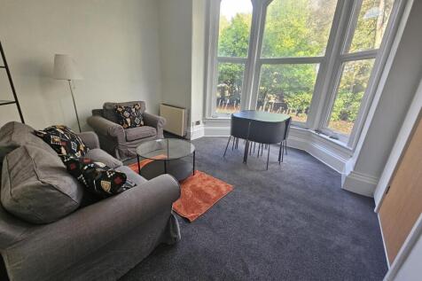 A bright and spacious living room featuring lar...
