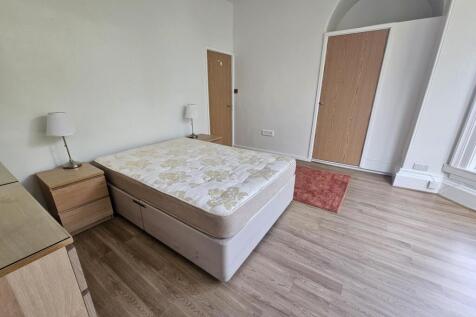 A bright and spacious master bedroom with a lar...