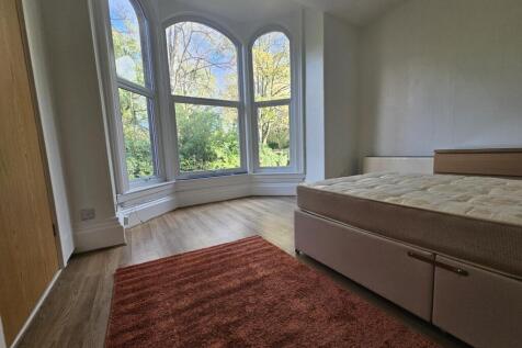 Bright and spacious master bedroom with large w...