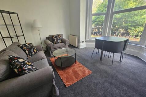 A bright and spacious living room with large wi...
