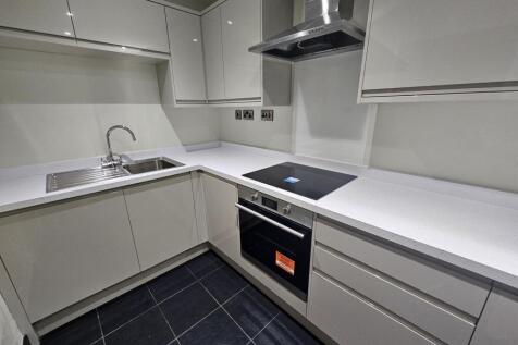 A modern and tidy kitchen with sleek white cabi...