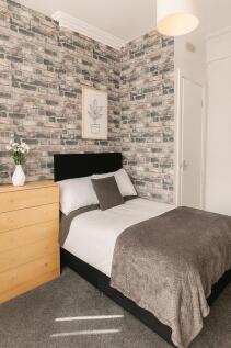 Stylish double bedroom with exposed brick-effec...
