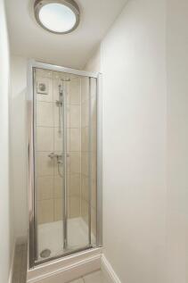 Bright, modern shower cubicle with tiled walls,...