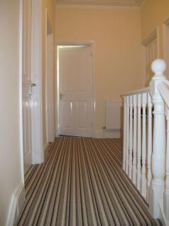 Bright, freshly painted upstairs hallway with d...