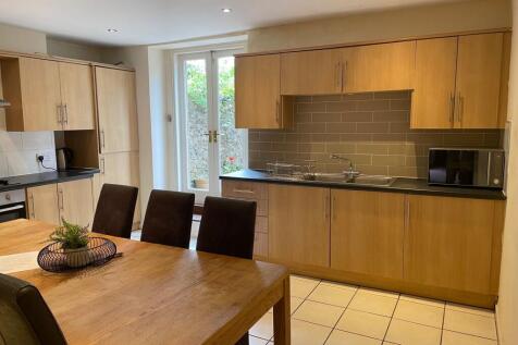 Modern eat-in kitchen with a large wooden dinin...