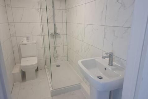 Bright modern bathroom with tiled walls, a walk...