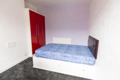 Neatly presented bedroom with a raised bed, uph...