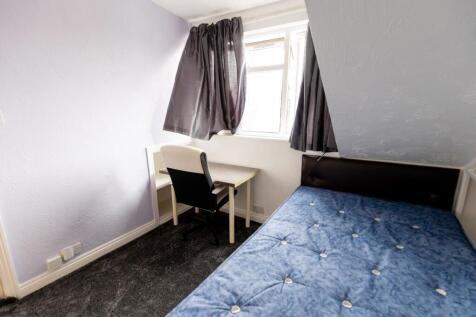 Bright upstairs bedroom with a fitted desk and ...