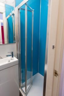 Compact bathroom with a modern corner shower cu...