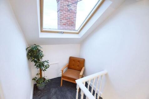 Bright top-floor landing with a large skylight,...