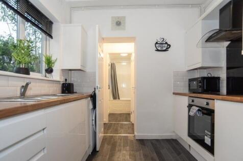 Bright modern galley kitchen with wood-effect w...