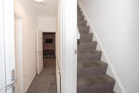 Bright, neutral hallway with carpeted floors an...